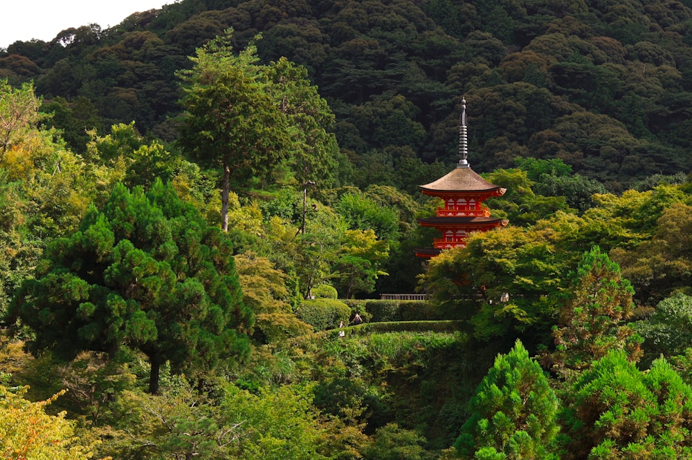 a red pagoda in the middle of a forest