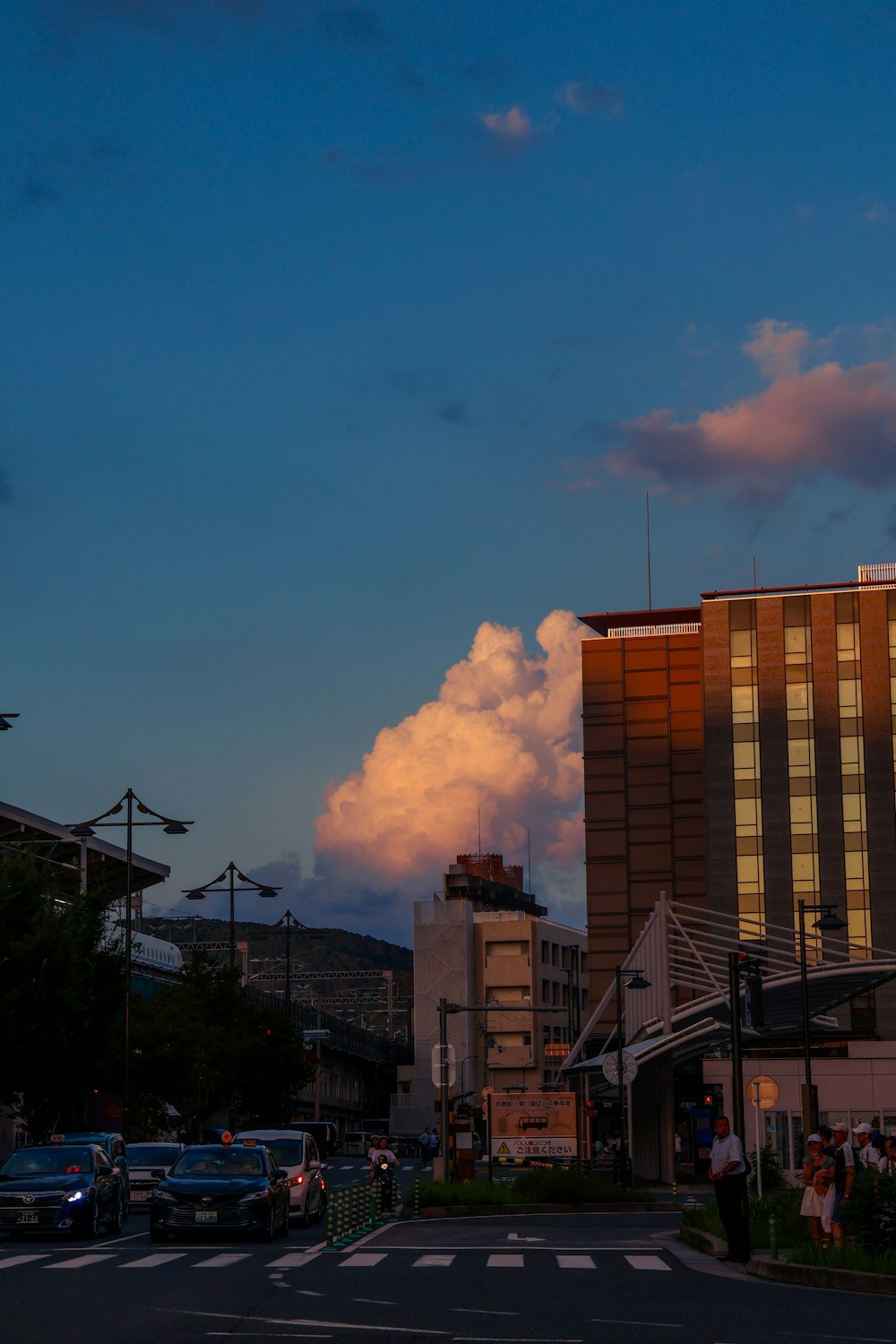 a city street at dusk with a cloud in the sky