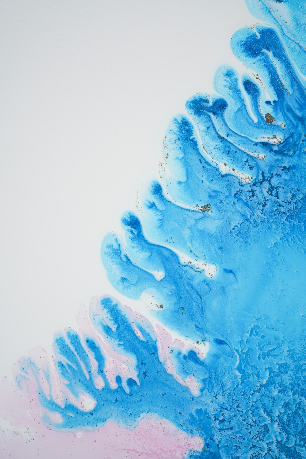 a close up of blue and pink paint on a white surface