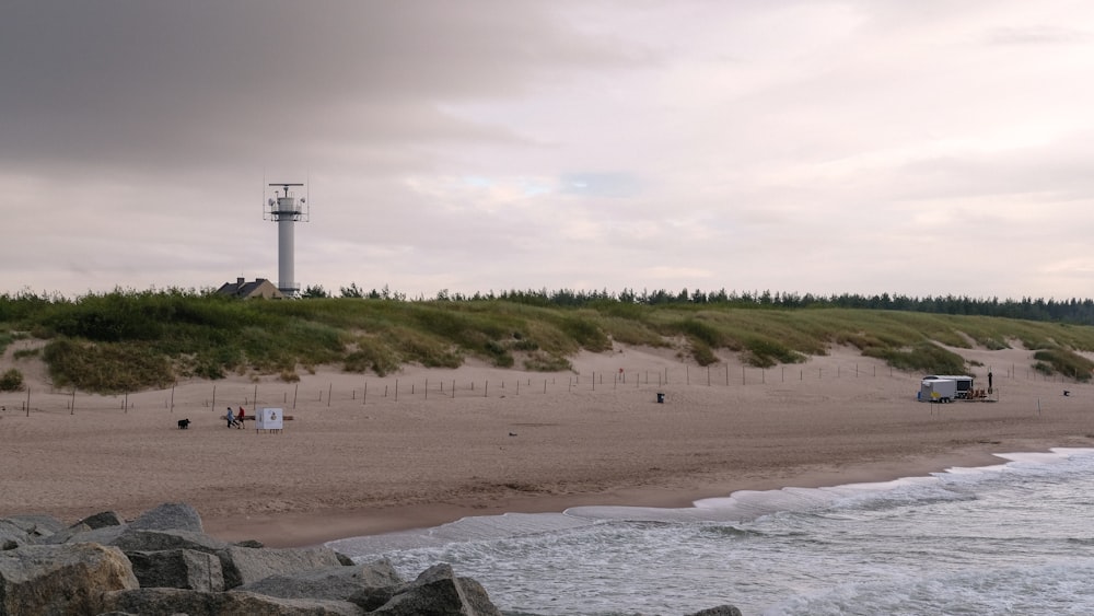 a sandy beach next to the ocean under a cloudy sky