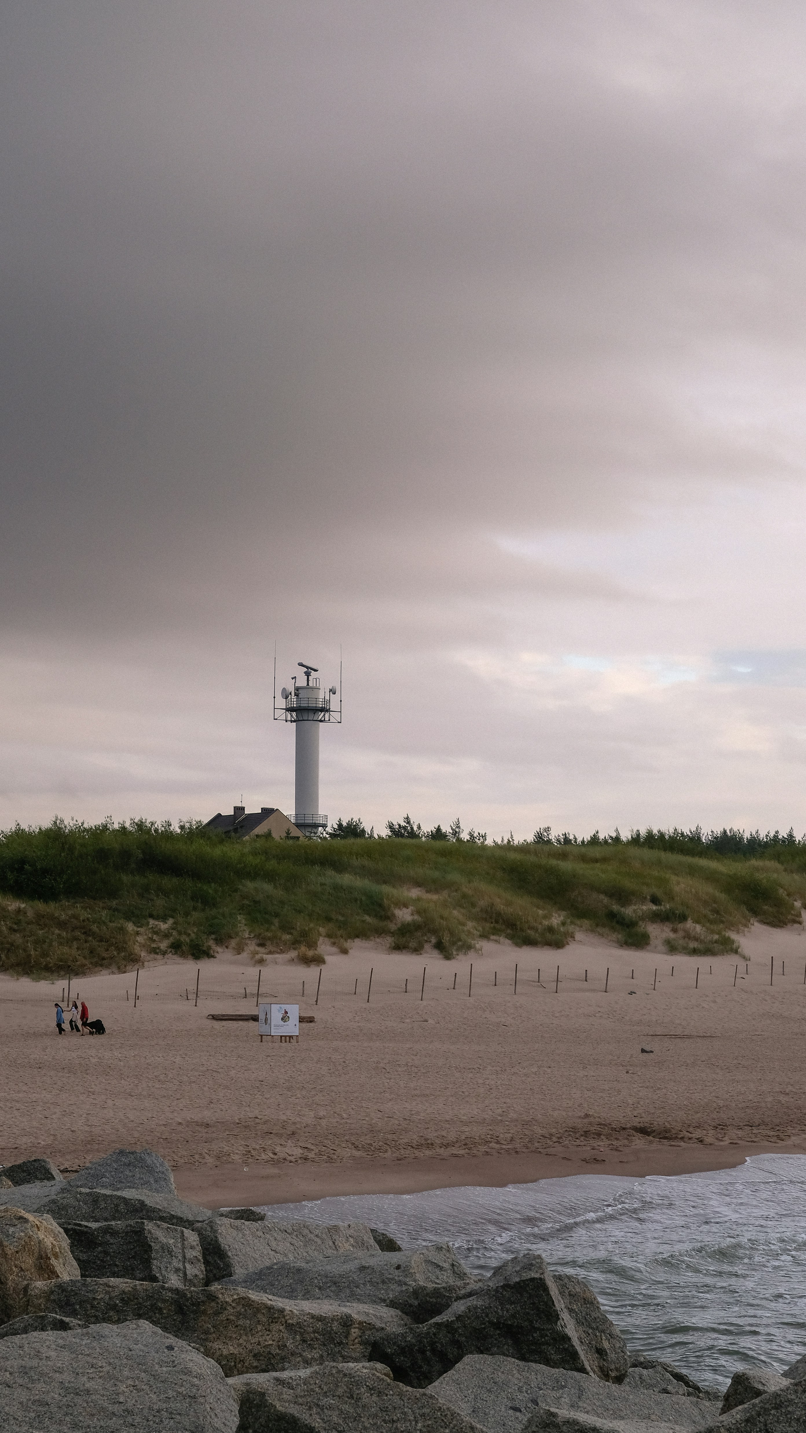 ein Strand mit einem Leuchtturm in der Ferne