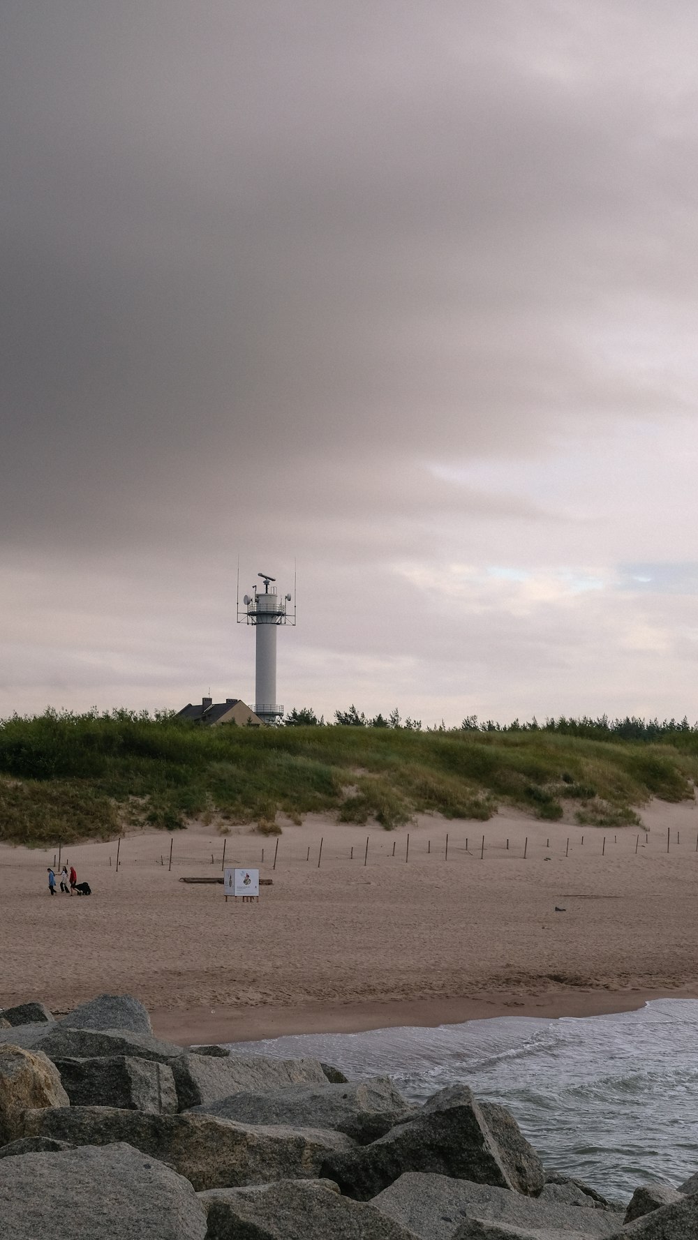 a beach with a light house in the distance