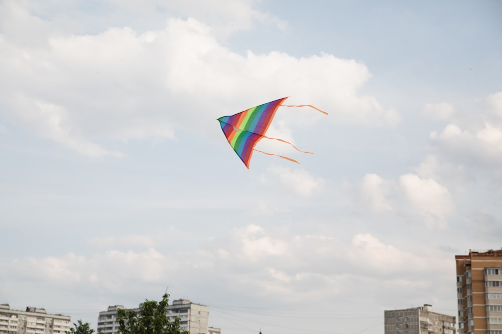 a colorful kite flying in the sky over a city