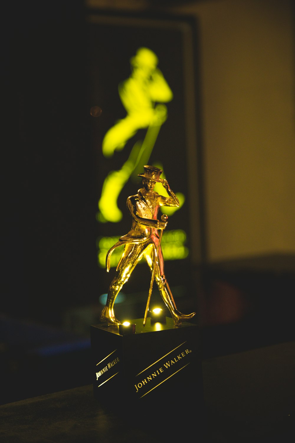 a golden statue of a person running on a black surface