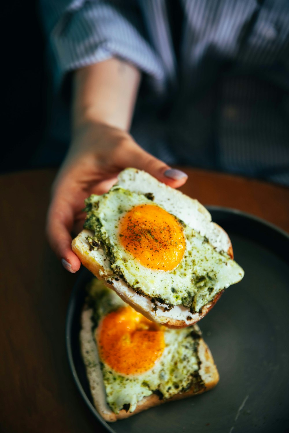 a person holding a piece of bread with eggs on it