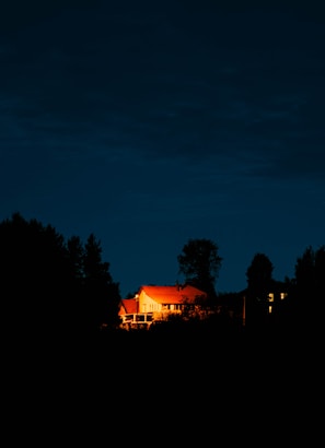 Evening shot of a completed house glowing warmly with lights on.