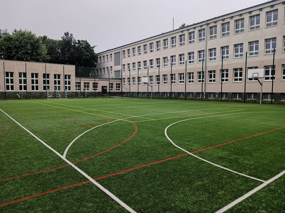 an empty soccer field in front of a building