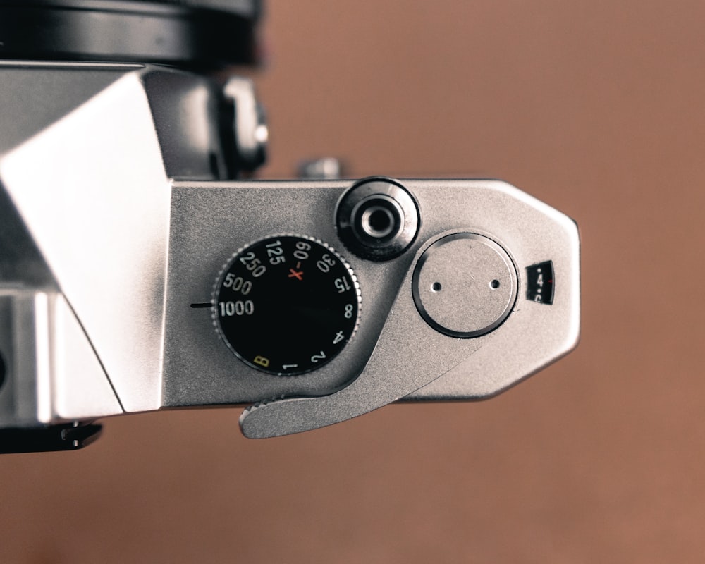 um close up de uma câmera com um fundo marrom
