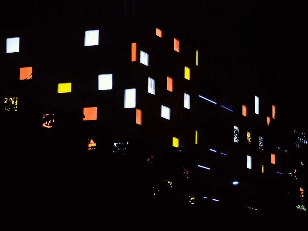 a building lit up at night with brightly colored lights