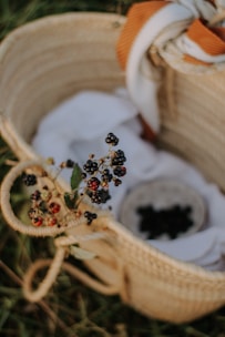Assortment of dried berries spilling from a woven basket on natural fabric
