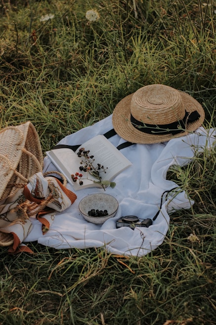 An open green park scene with a picnic setup, a bicycle helmet and outdoor gear subtly placed