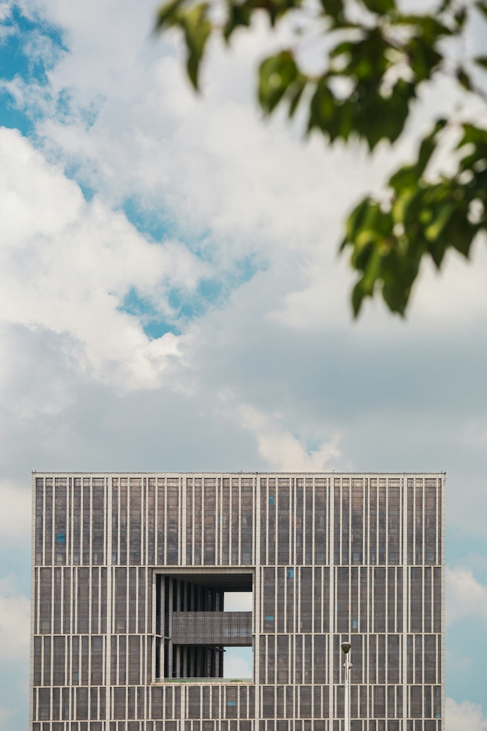 a tall building sitting under a cloudy blue sky