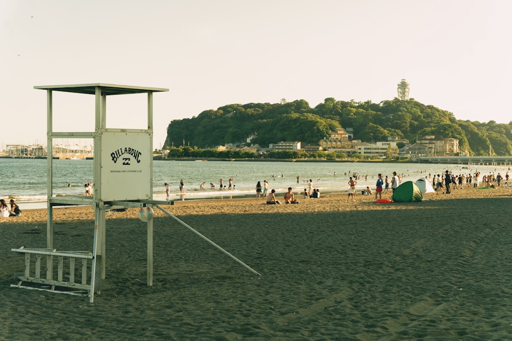 a lifeguard stand on a beach with people in the water
