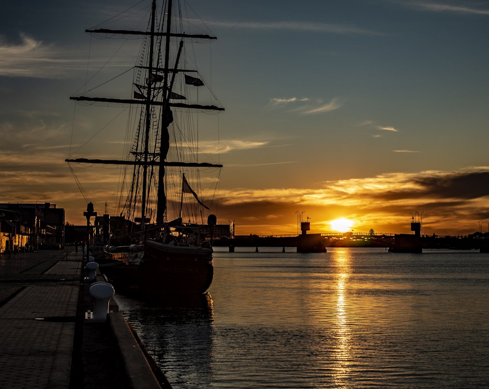 a boat is docked in the water at sunset