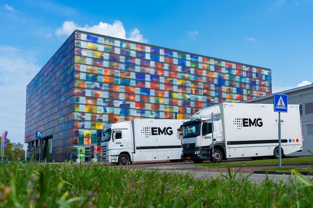 two trucks parked in front of a multi - colored building