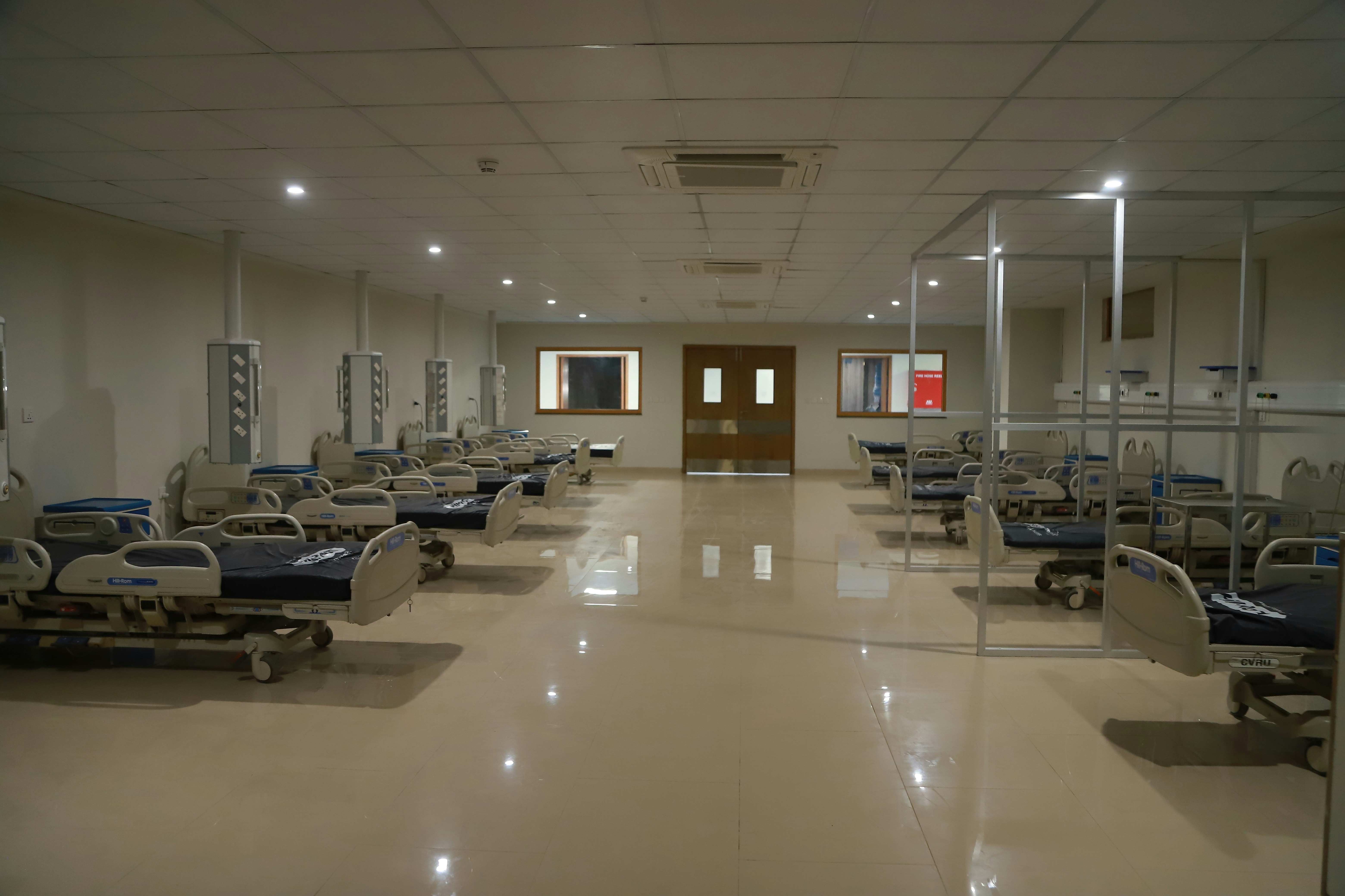 Hospital ward with medical equipment including beds and monitoring devices in a well-lit facility