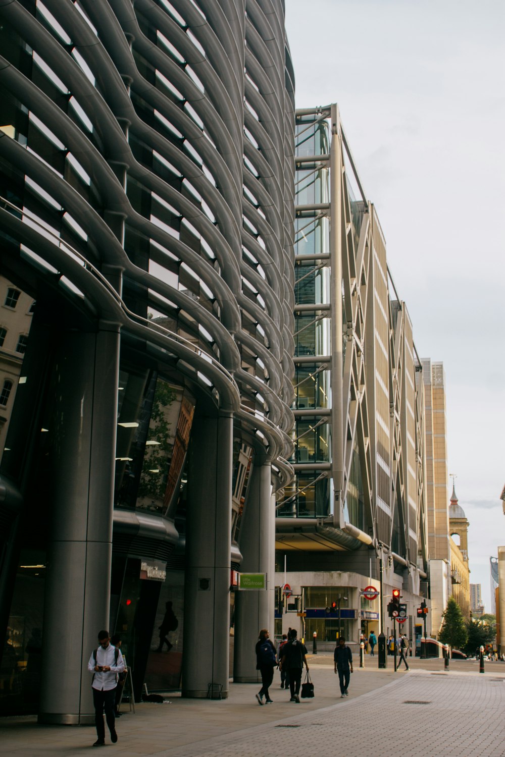 a group of people walking down a street next to tall buildings