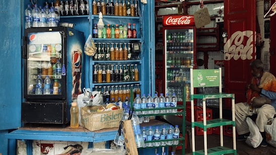 A friendly distributor handing over crates of Campa Cola bottles to a local store owner.