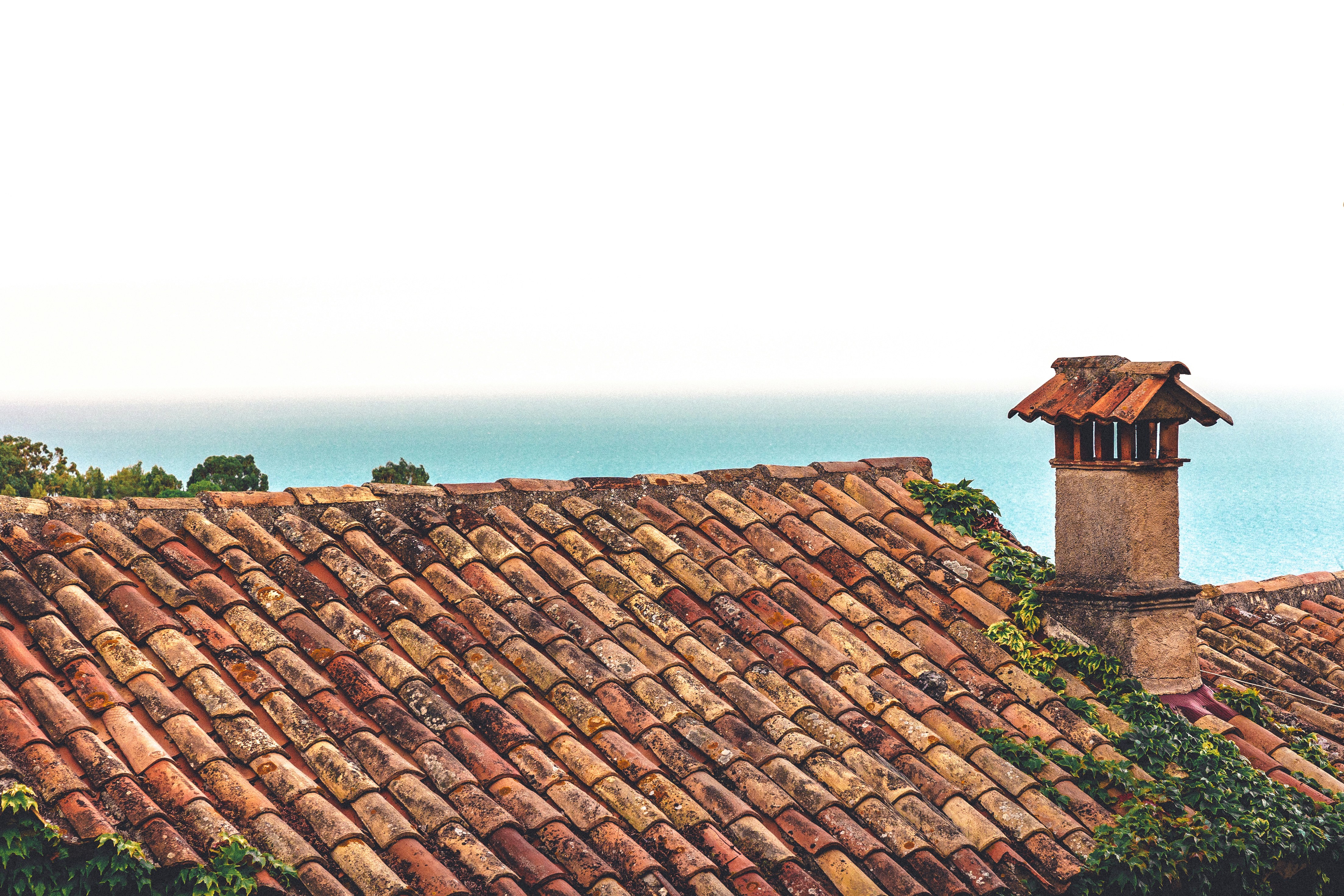 a view of a tiled roof with a clock tower