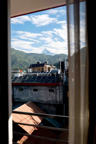 Close-up of solar water heater panels installed on a sloped roof with mountain backdrop