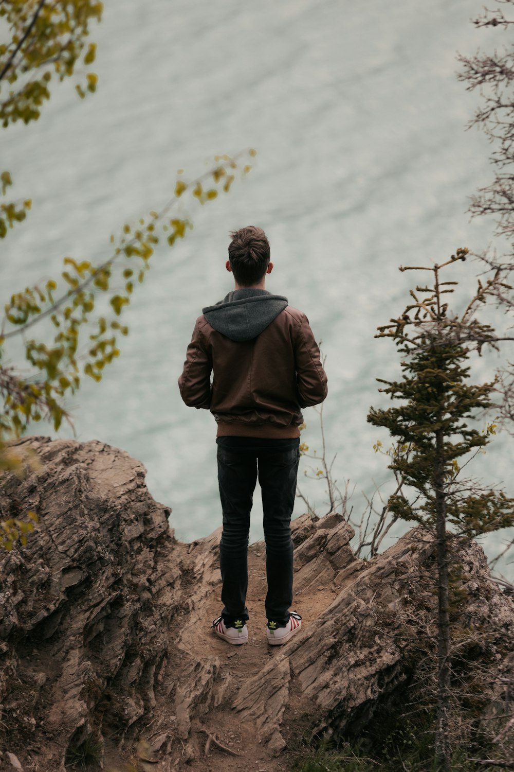 a man standing on a cliff overlooking the water