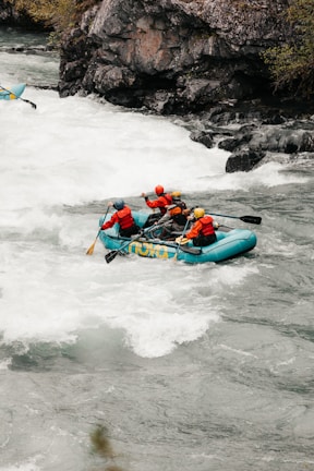A certified instructor demonstrating safety techniques to attentive young participants near a river.