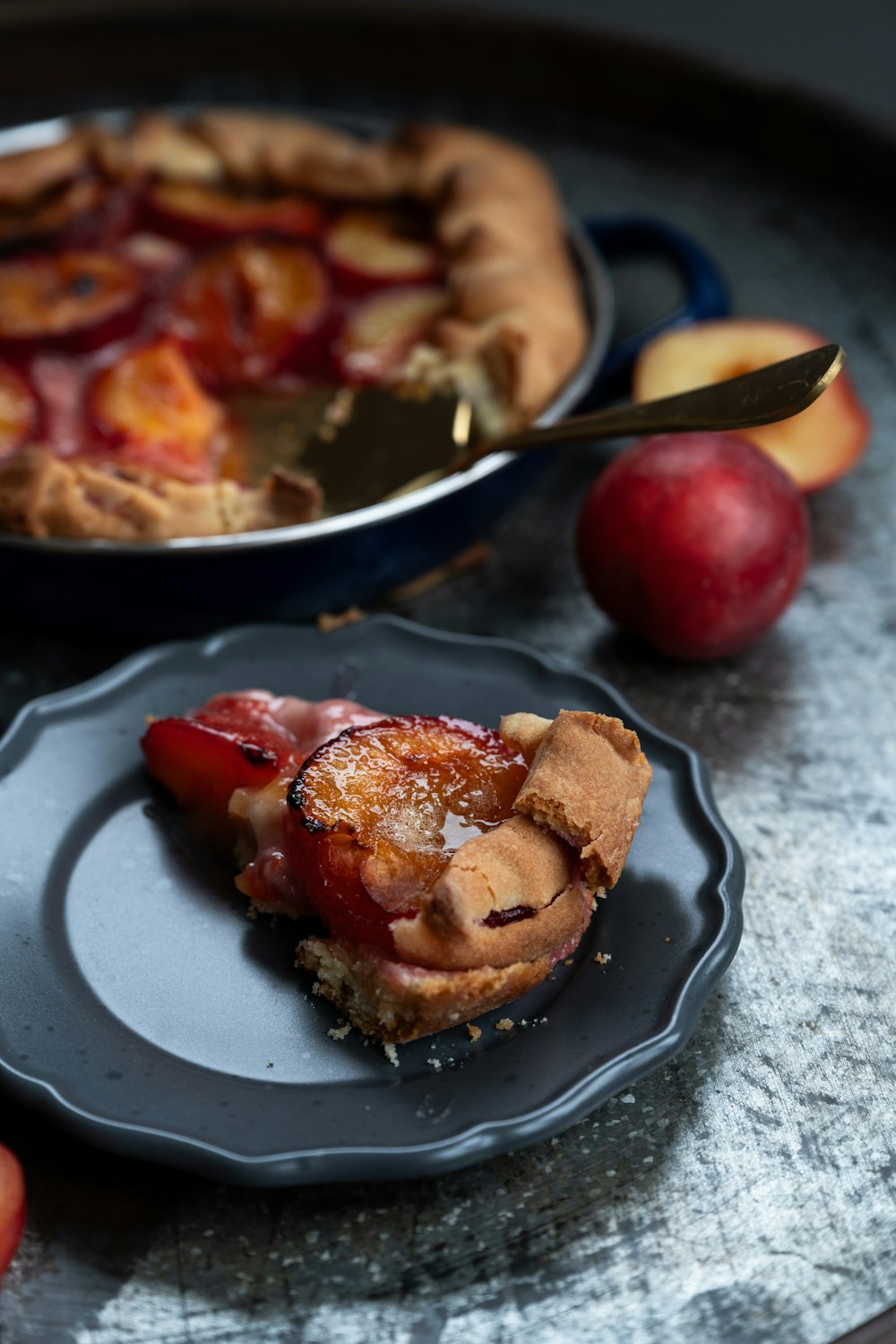 a piece of pie on a plate next to an apple