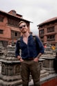 a man with a backpack standing in front of a building
