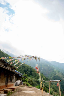 Sun-drenched Tibetan monastery perched on a mountain ridge with fluttering prayer flags.