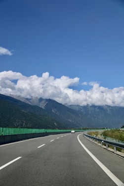 A scenic highway winding through mountains under a clear blue sky.