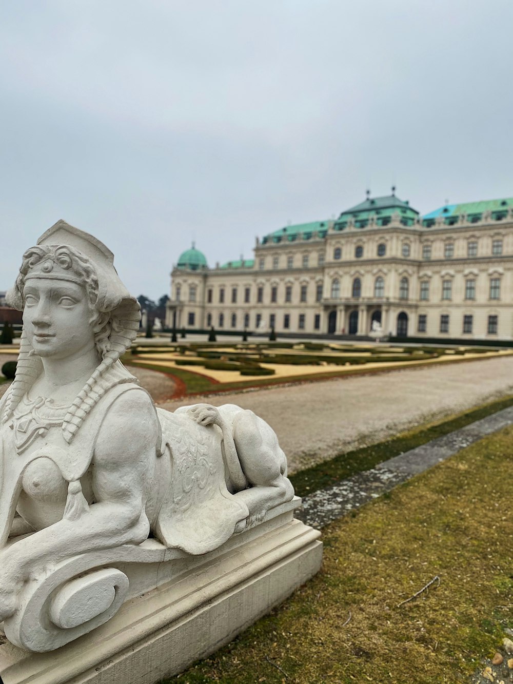 a statue of a woman sitting in front of a building