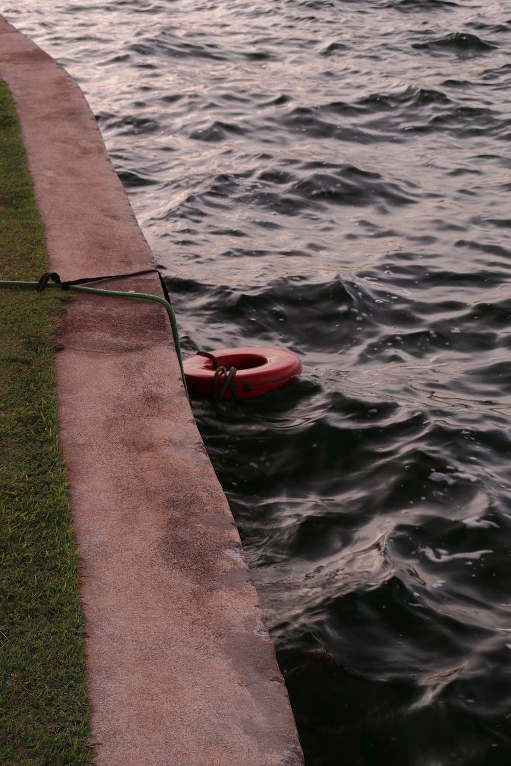 a life preserver tied to a concrete wall by the water