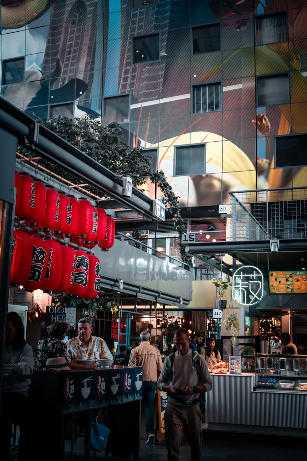 a group of people standing around a food court