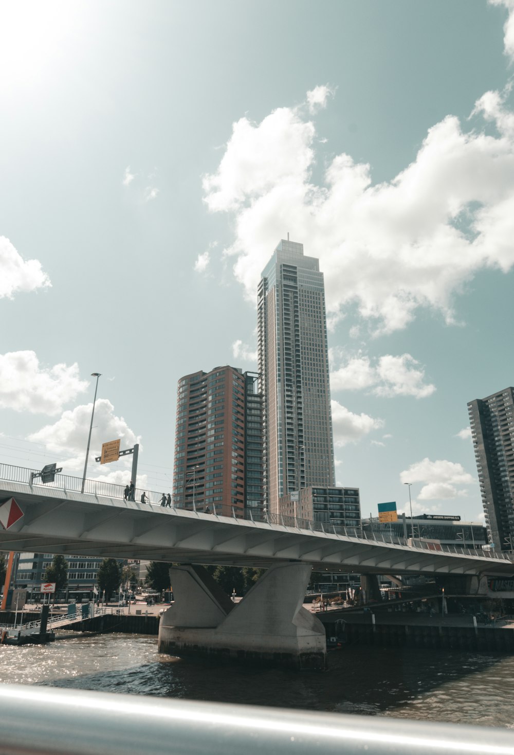 a bridge over a body of water with tall buildings in the background