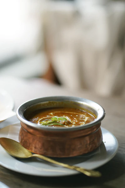 a bowl of soup on a plate with a spoon