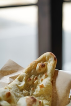 a slice of pizza sitting on top of a napkin