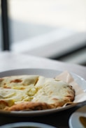A close-up of freshly baked naan bread served with a side of rich curry.