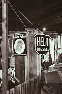 A rustic indoor setting with vintage signs, including one advertising diesel and another for a household product. There are wooden structures, a wicker basket, and assorted vintage items creating a retro atmosphere.