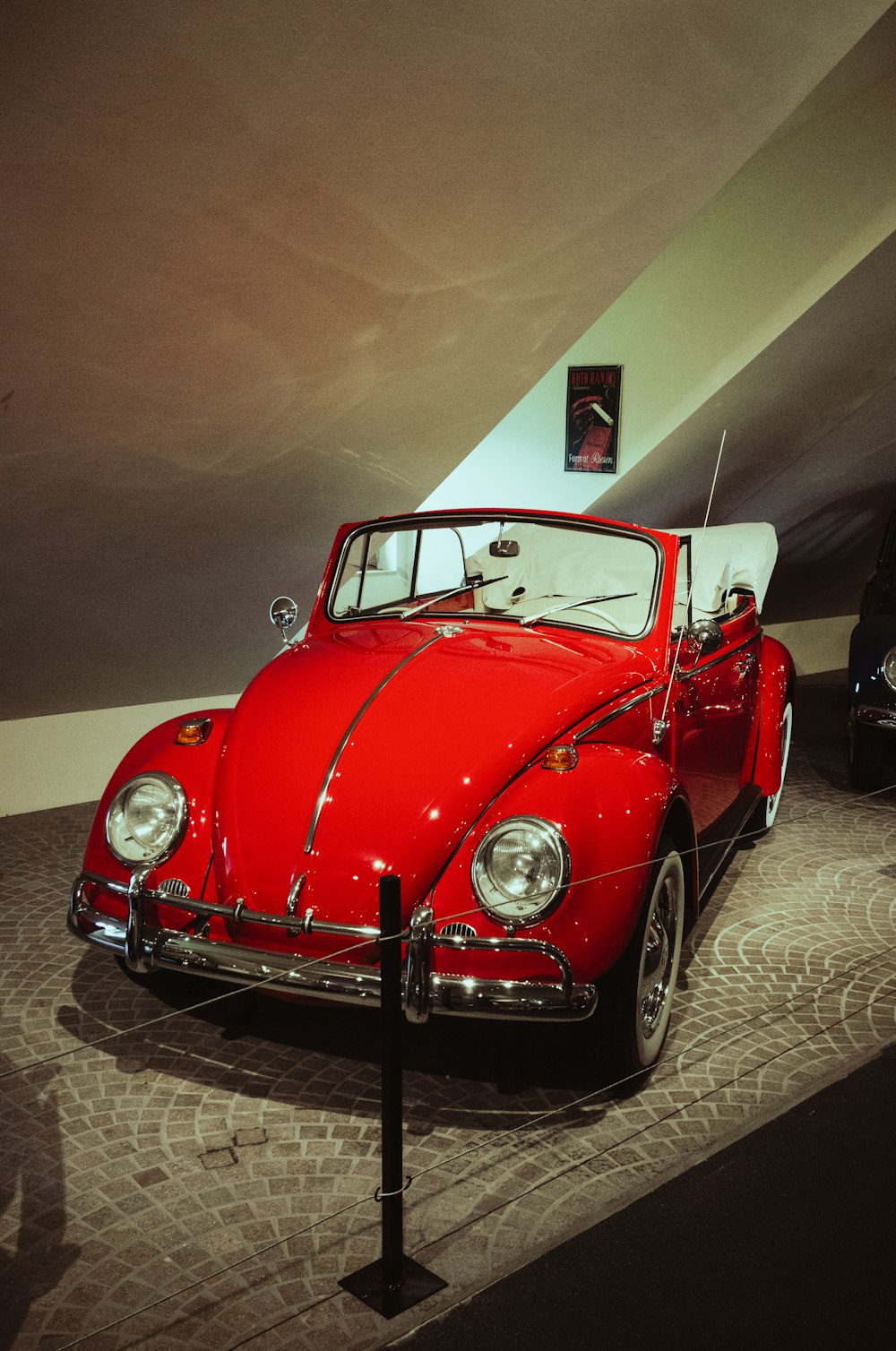 a red vw bug is on display in a museum
