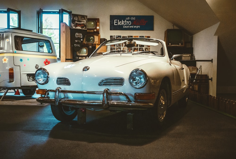 a white car parked in a garage next to another car