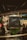 An antique Guldner Diesel tractor is displayed indoors against a rustic wooden backdrop. The tractor's vintage design features large round headlights and a prominent grill. It is surrounded by gravel and a rope barrier, enhancing its classic and preserved appearance.