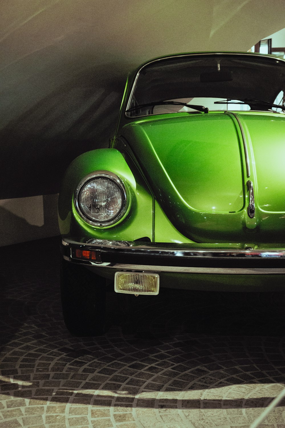 a green car is parked in a garage