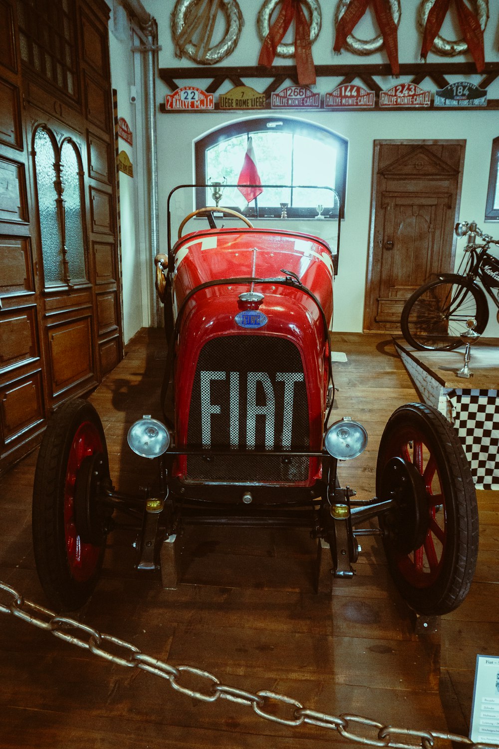 a vintage red car is on display in a museum