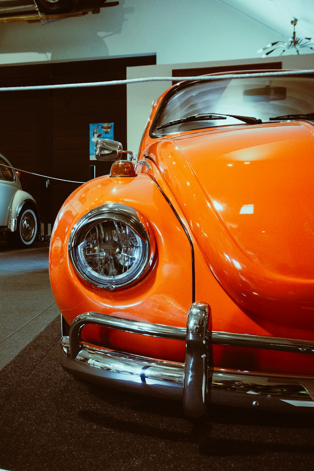 Ein orangefarbener VW-Käfer ist in einem Museum ausgestellt