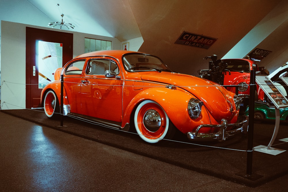 an orange car is on display in a museum