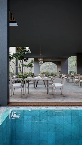 An elegant outdoor dining set arranged on a wooden deck surrounded by greenery.