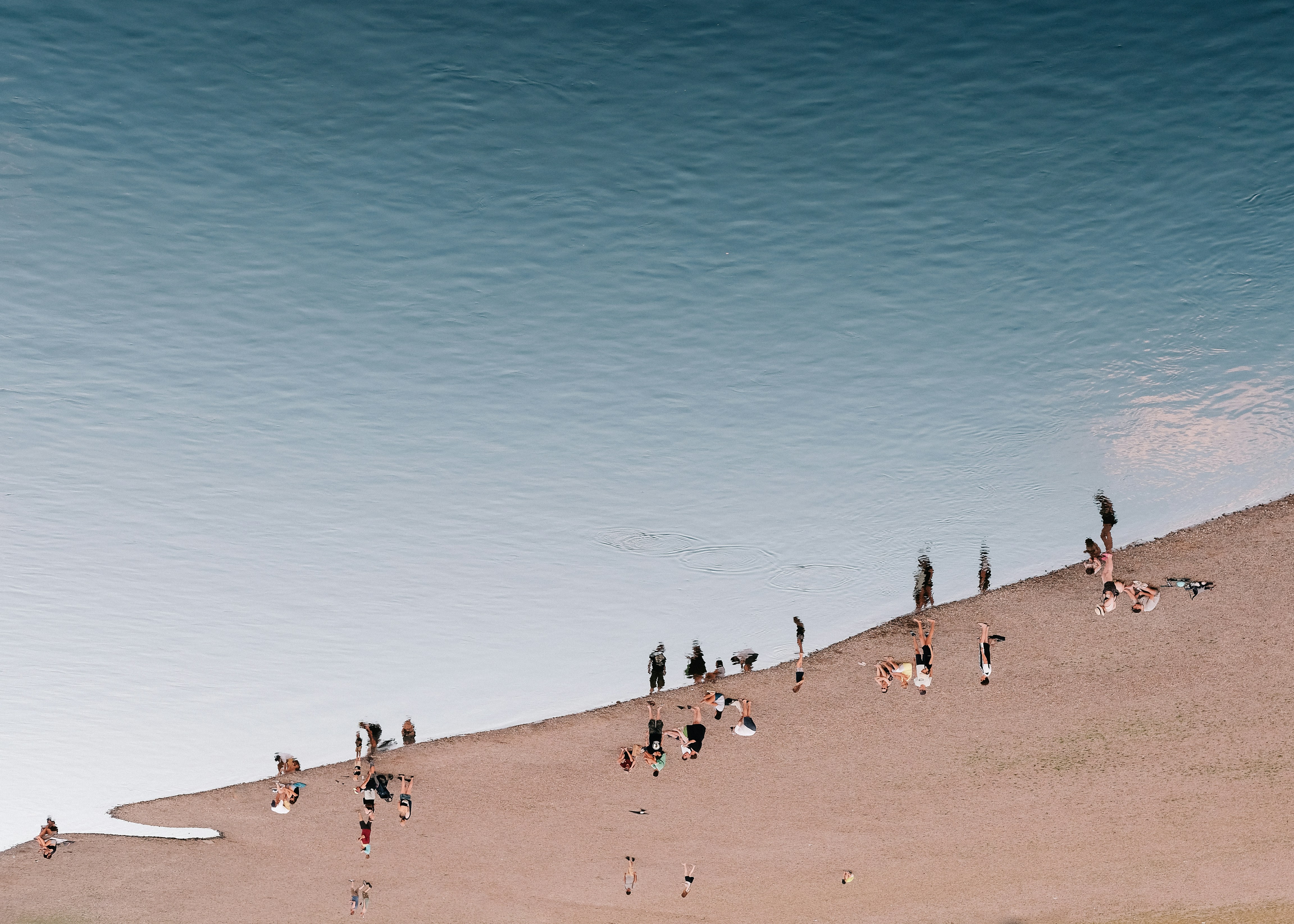 Un grupo de personas de pie en la cima de una playa de arena