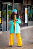 a woman in yellow pants and a blue coat