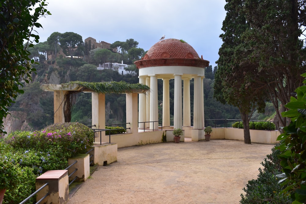 a gazebo surrounded by trees and bushes on a cloudy day