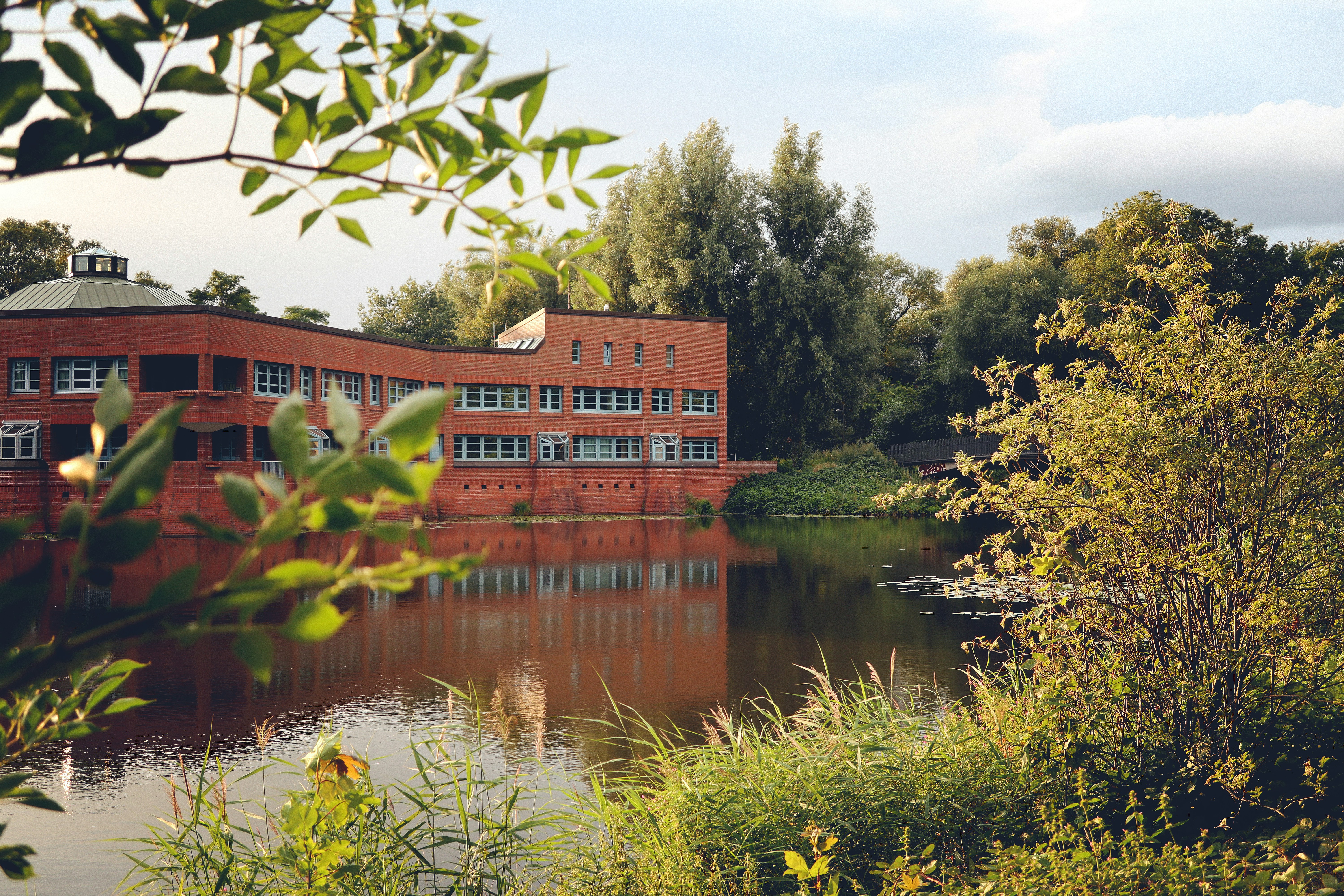 a red building sitting on the side of a river